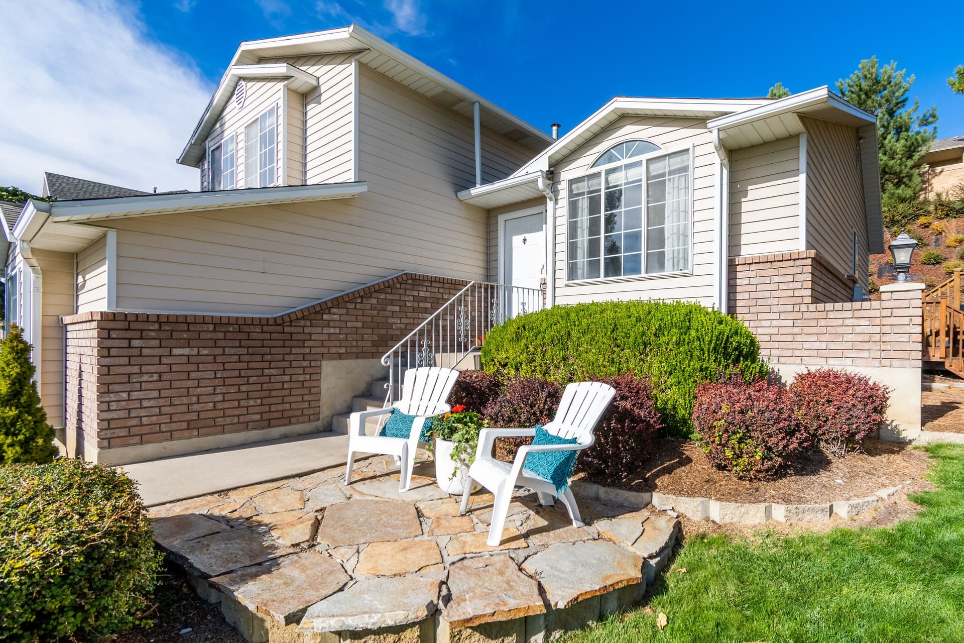A sunlit home with a welcoming front entry, garden and outdoor seating