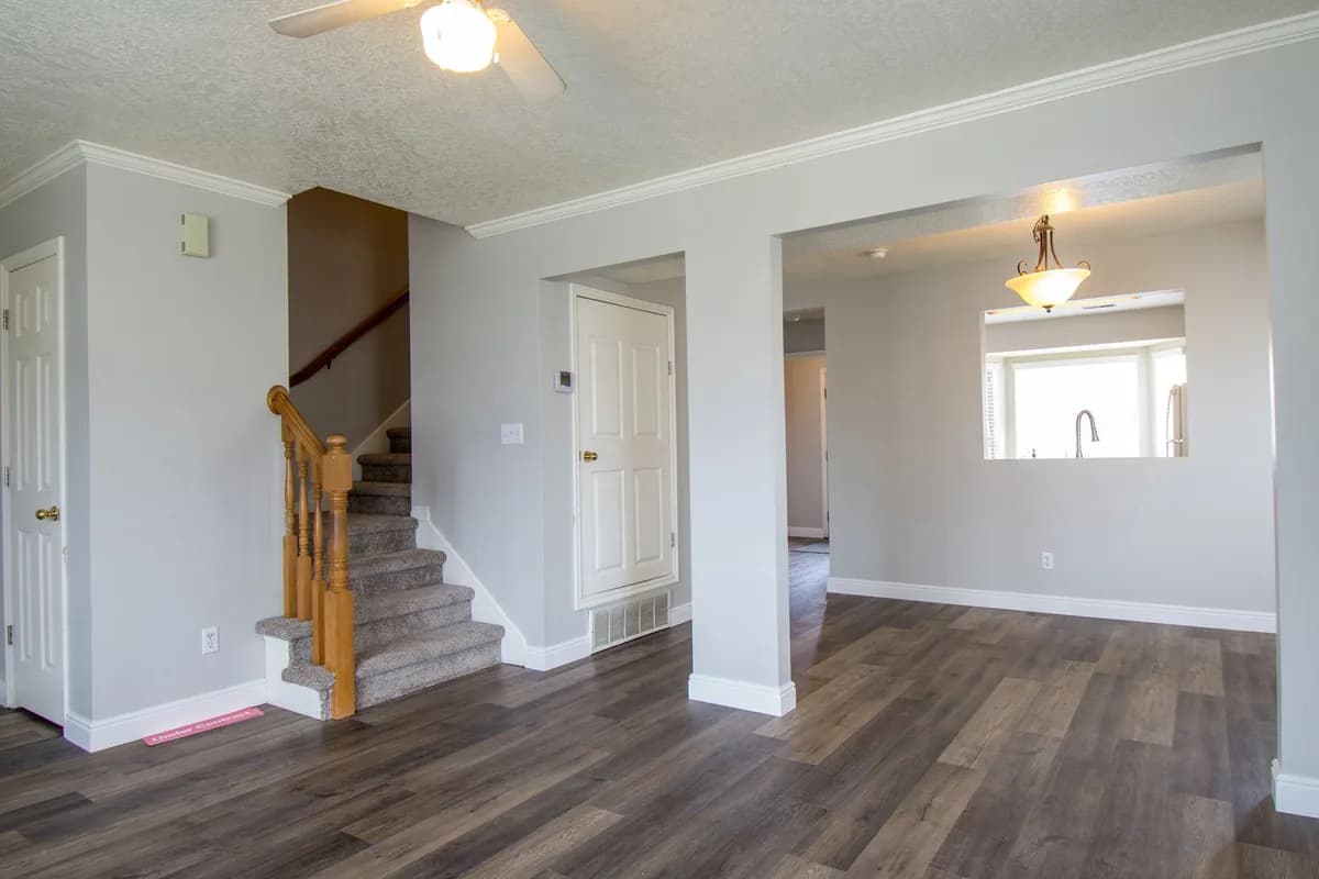 An unfurnished room with stairs and wood flooring