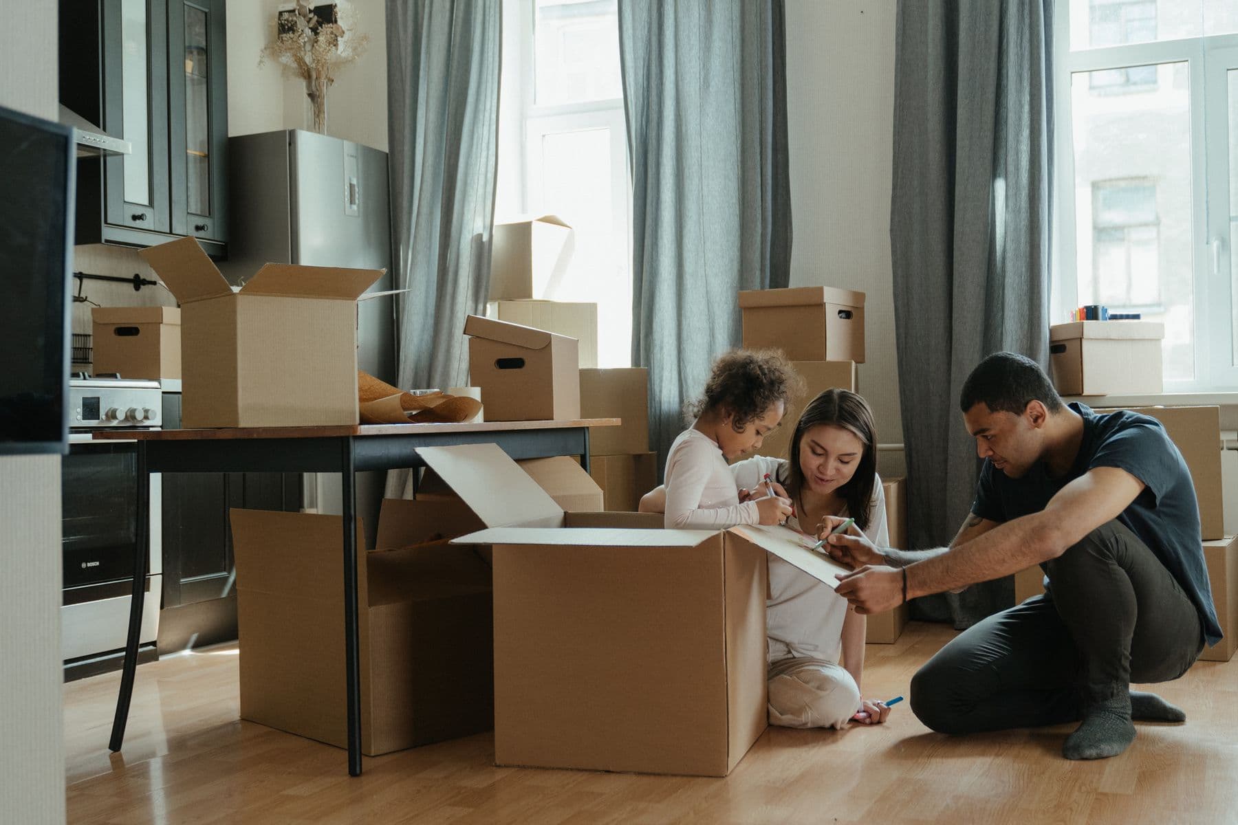 A family sharing a quiet moment while unpacking in their new home