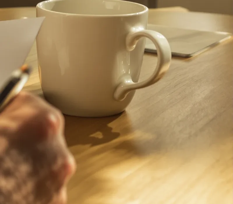 A cash-offer agreement ready to sign over coffee at a homeowner's kitchen table